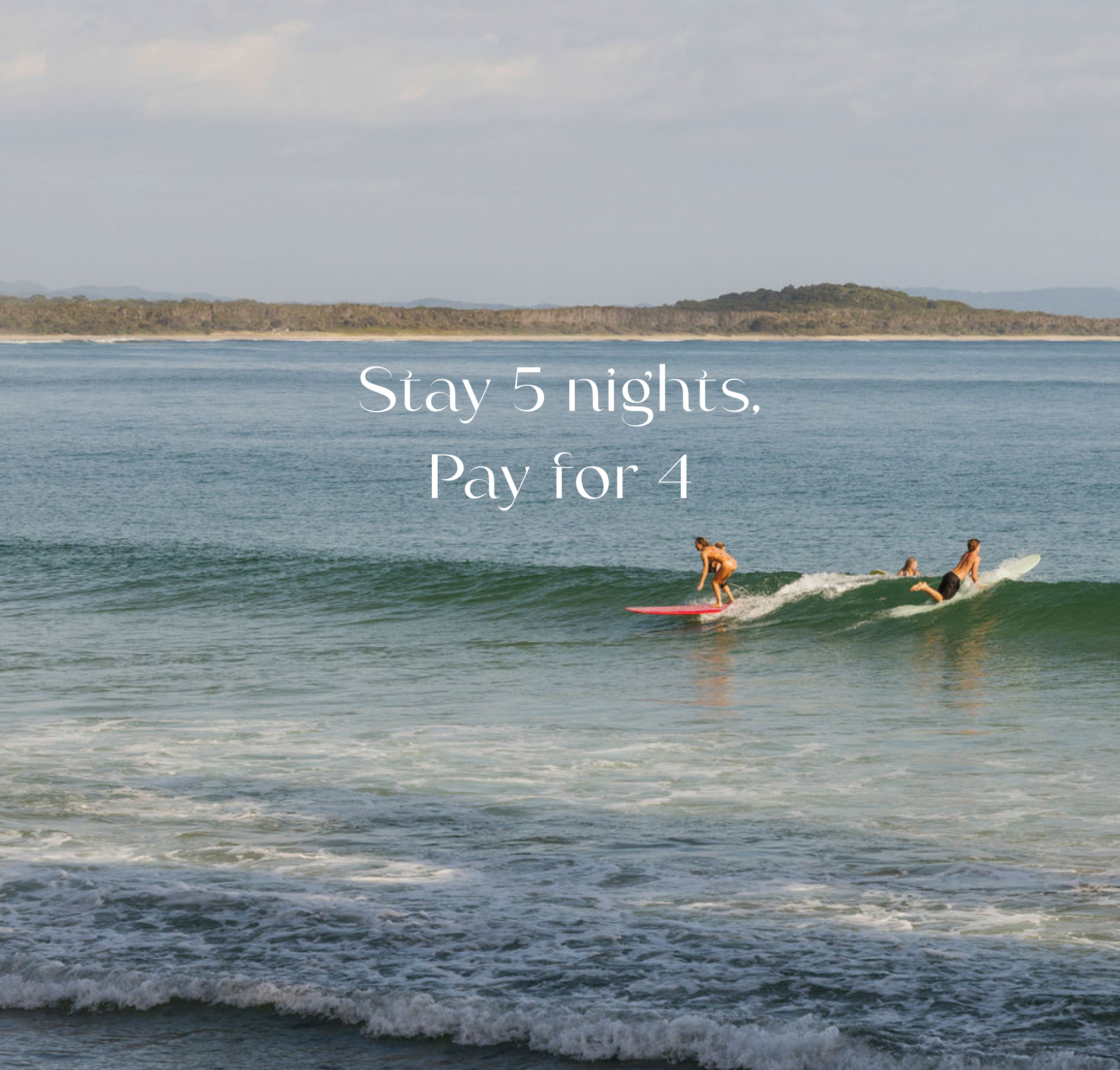 Two surfers surfing a wave at Noosa Main Beach - Stay 5 nights, Pay for 4