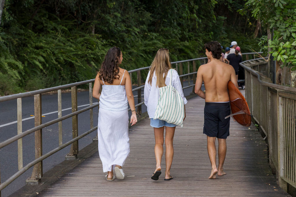Three people walking on the boardwalk to the Noosa National Park